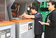 Residents of Seoul's Mapo-gu District dispose of food waste in weight-calculating bins. (Yonhap News)