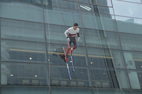 마천루 빌딩 벽을 타고 내려오는 크로스컨트리 스키 선수.
